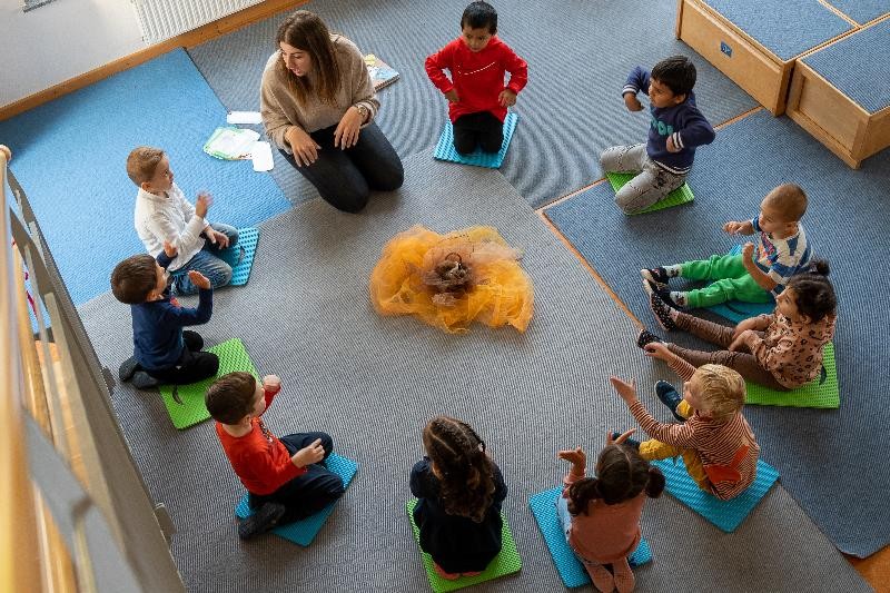 Kinder sitzen im Kreis