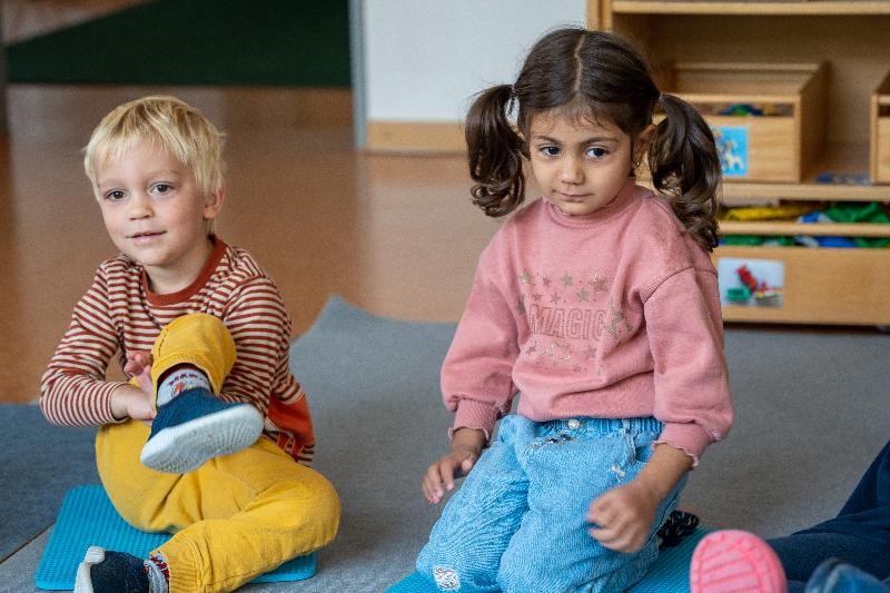 zwei Kinder sitzen auf dem Boden