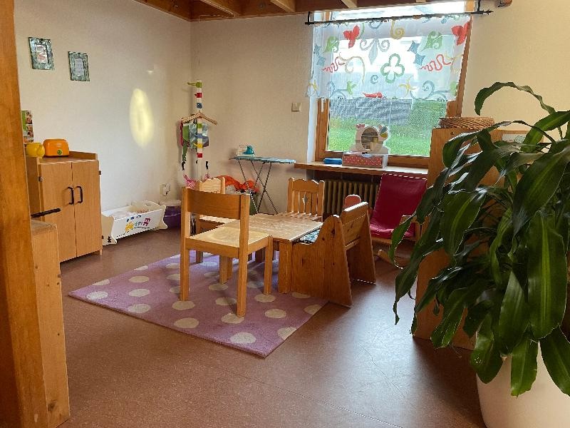 Rollenspielbereich Tisch mit Stühlen, Wiege, Bügeleisen und Kinderschrank