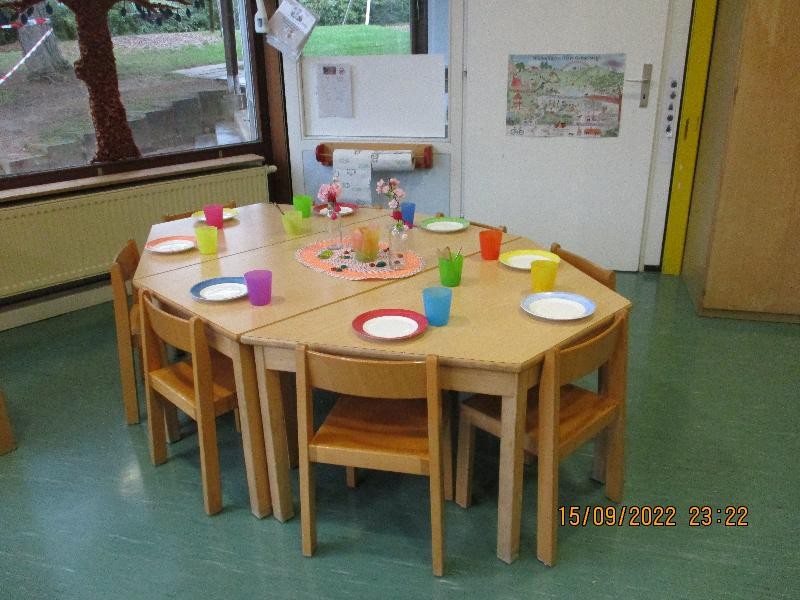 gedeckter Tisch mit bunten Tassen und Tellern
