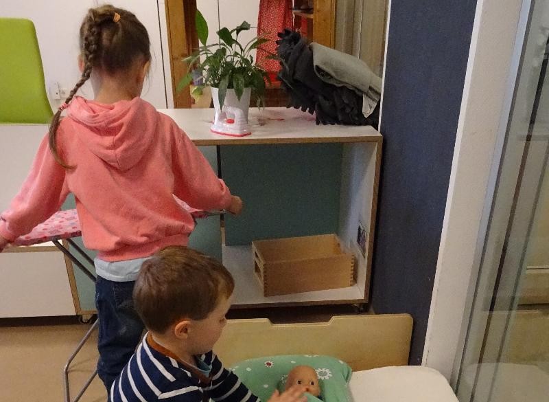 Kinder spielen in der Puppenecke