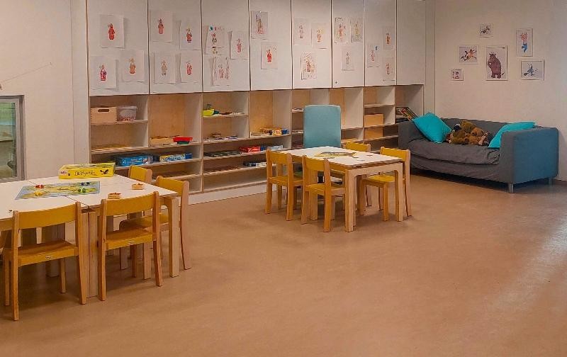 Zimmer mit Teppich, Tisch und Spiele