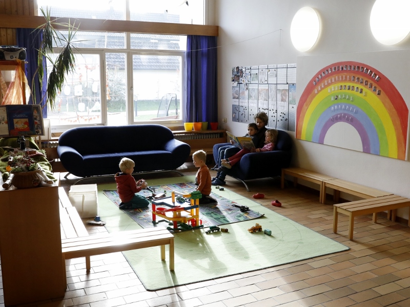 Gruppenraum spielende Kinder auf dem Teppich