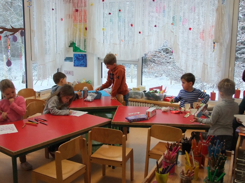 Gruppenraum Kinder sitzen am Maltisch