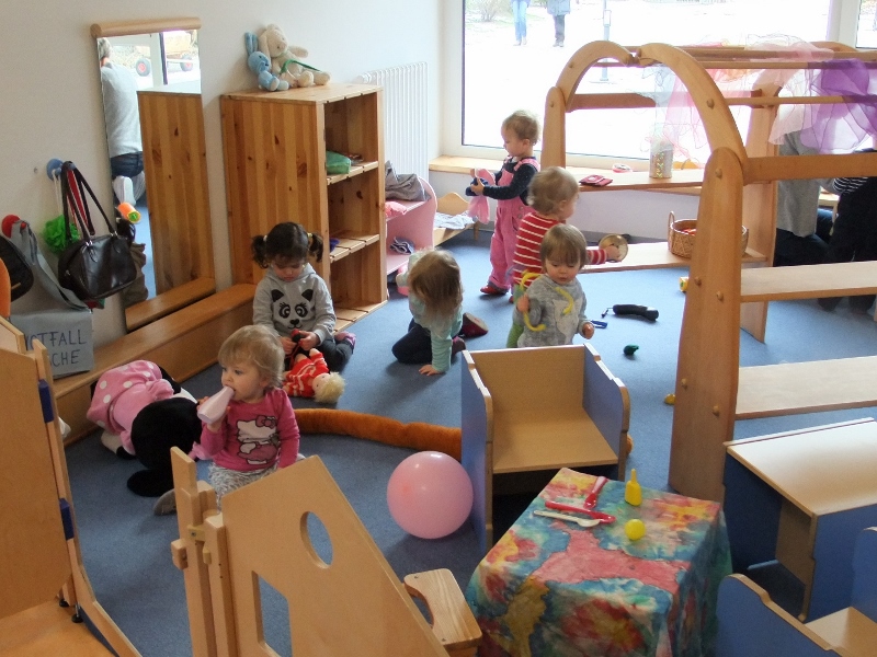 Gruppenraum Kinder spielen mit Puppengegenständen