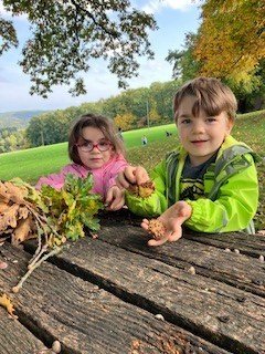 Zwei Kinder zeigen ihre Kastanien